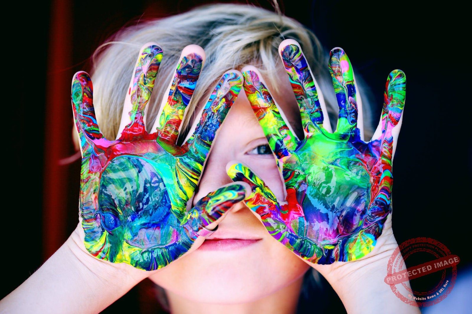 a kid with multicolored hand paint
